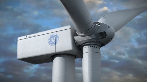 Wind turbine with GE logo in front of a cloudy sky.