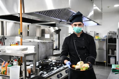 Chef with facemask in commercial kitchen