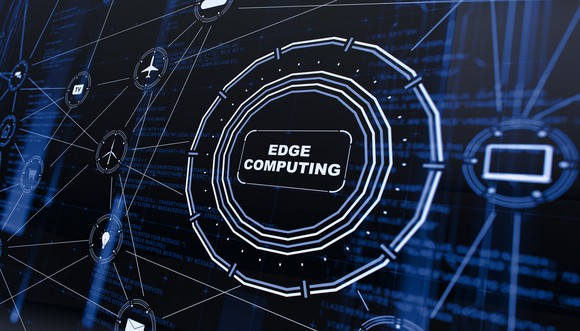 The words Edge Computing in a circle in the center of the universe of computers, airplanes mail, and light bulbs.