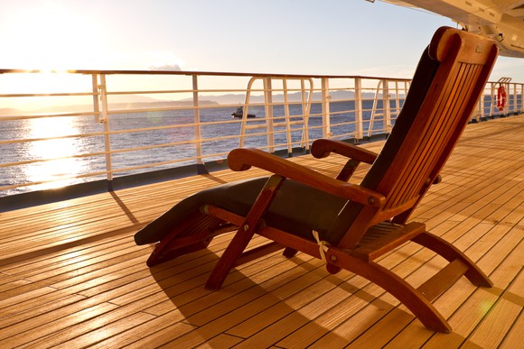 A lounge chair facing the sun on the deck of a cruise ship.
