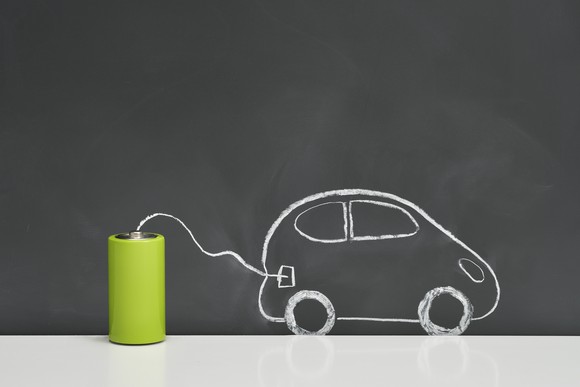 A drawing of a car being charged by a battery.
