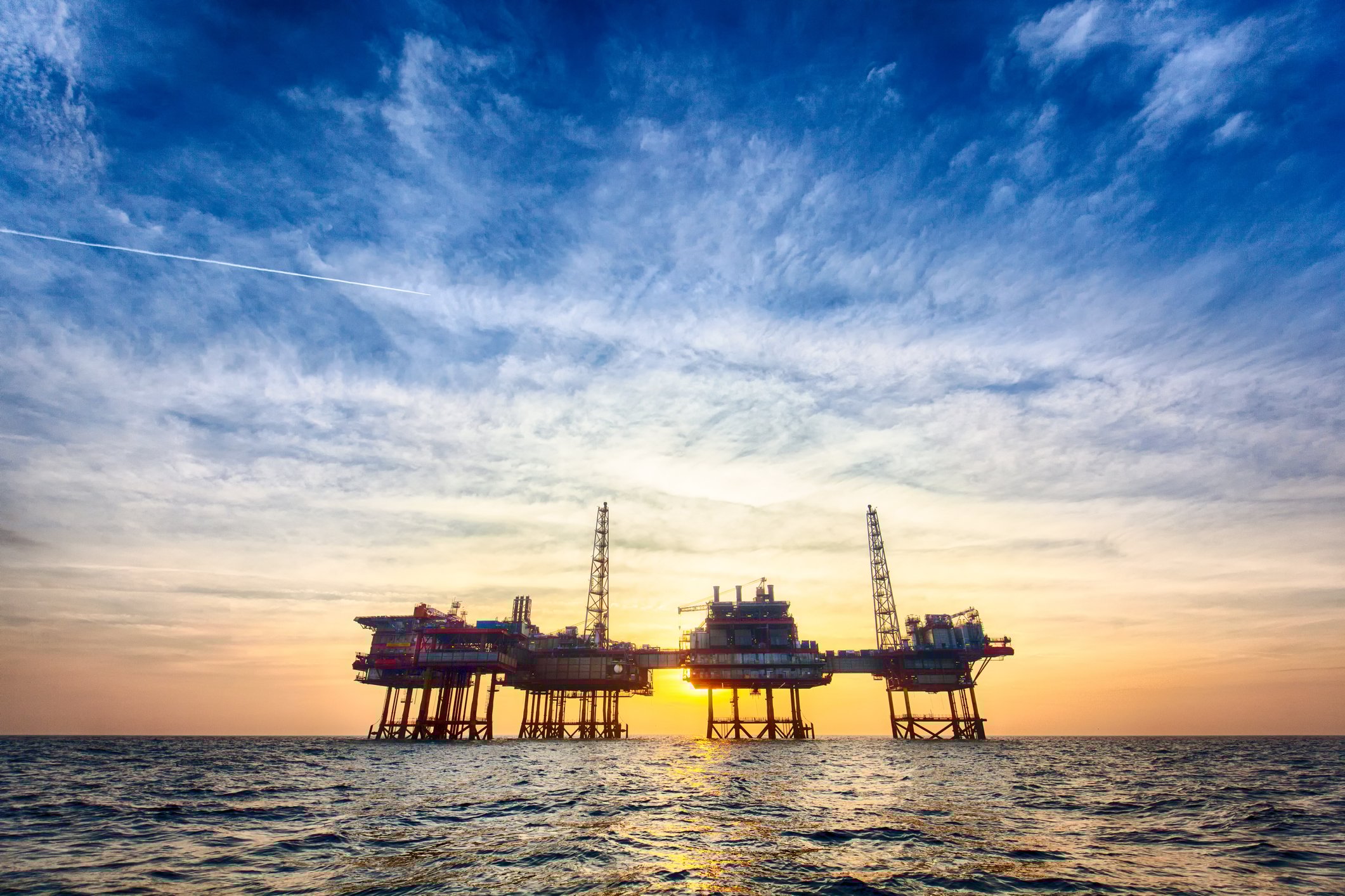 Offshore oil platform at sunset. 