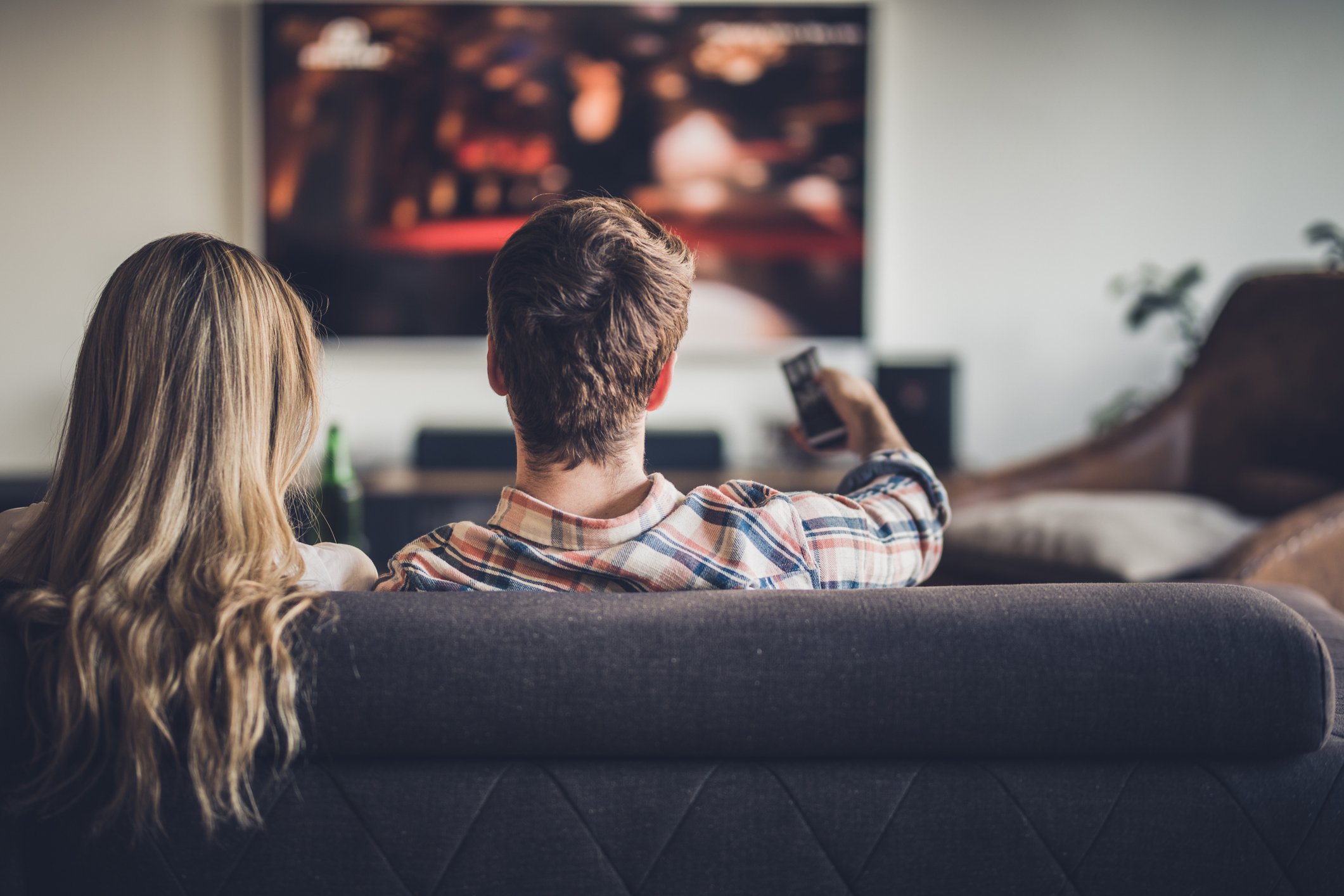 Couple watching TV on the couch. 