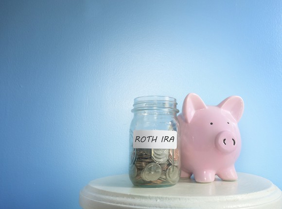 Piggy bank next to jar labeled ROTH IRA 