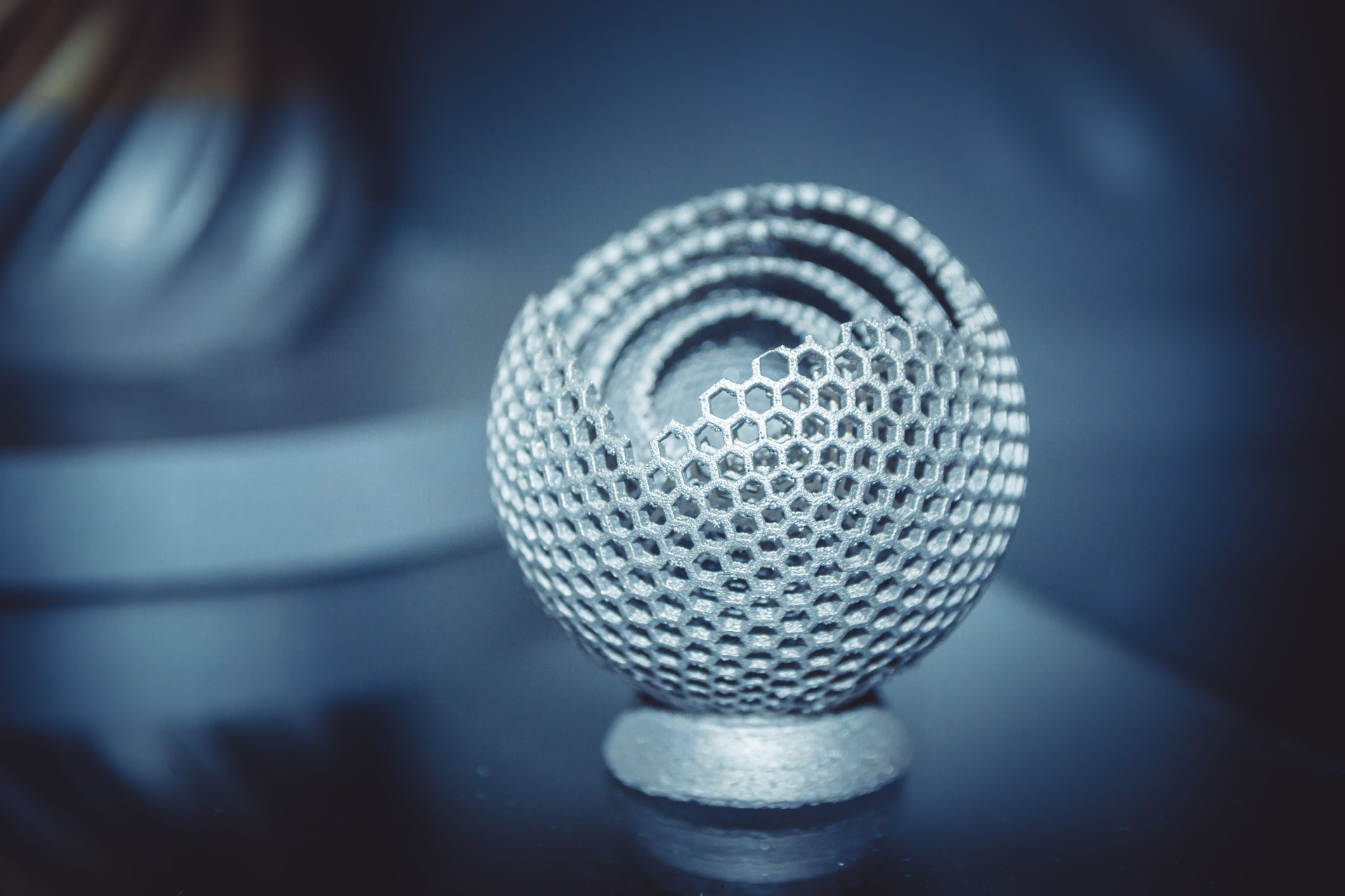 A 3D-printed spherical  metal shape with hexagonal pores. 