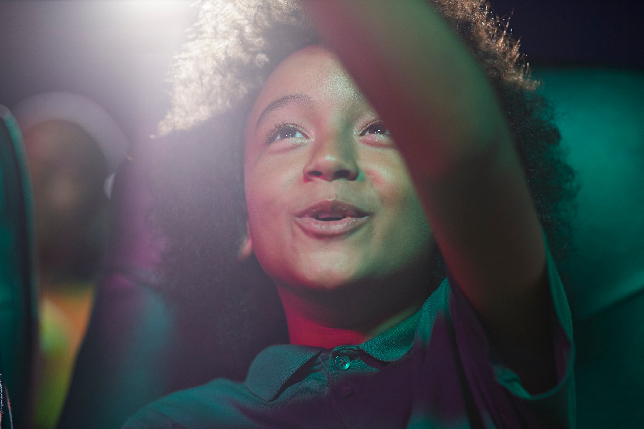 A child watching a movie in a theater.