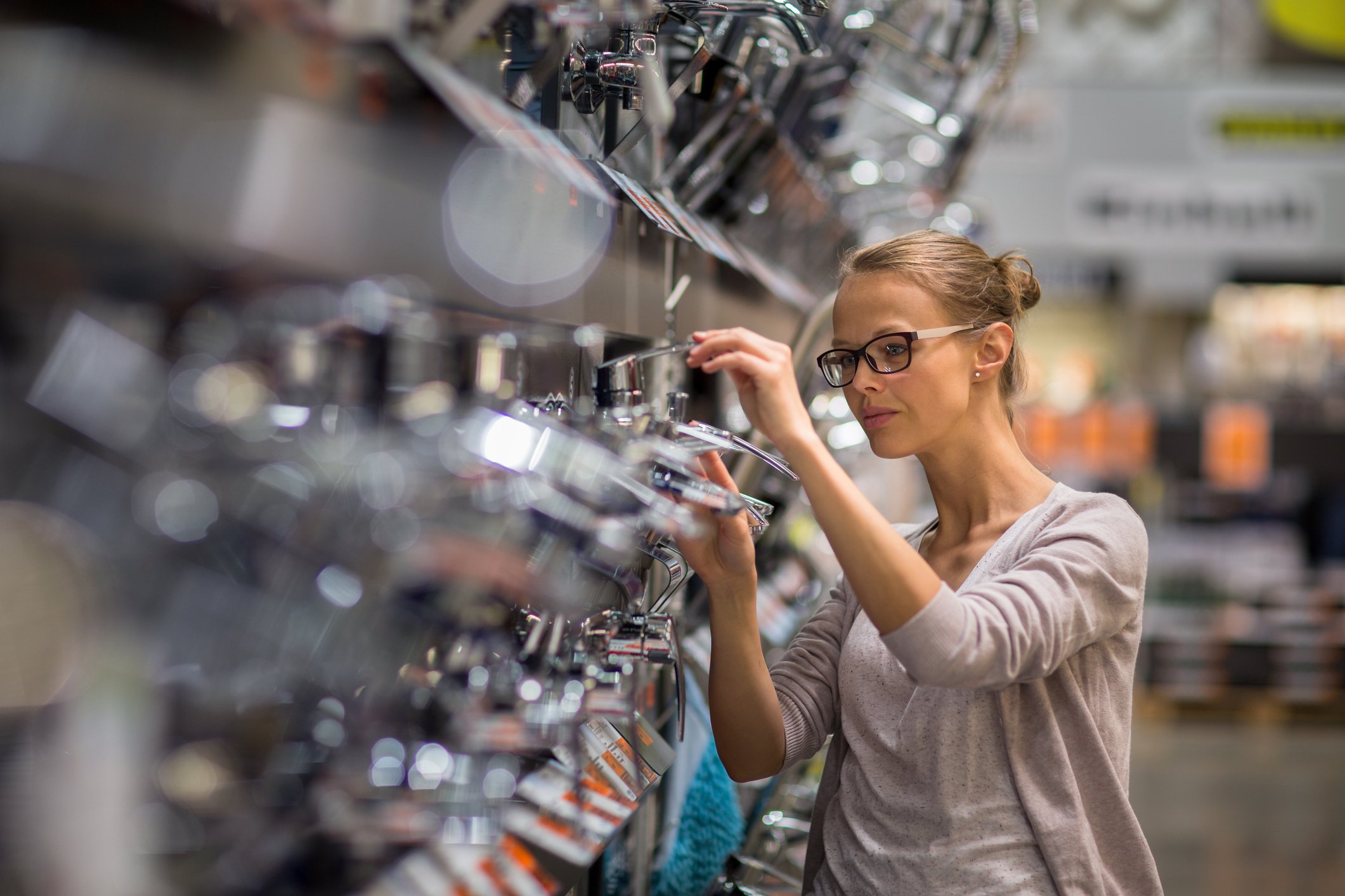 Woman browsing cookware in a home goods store.