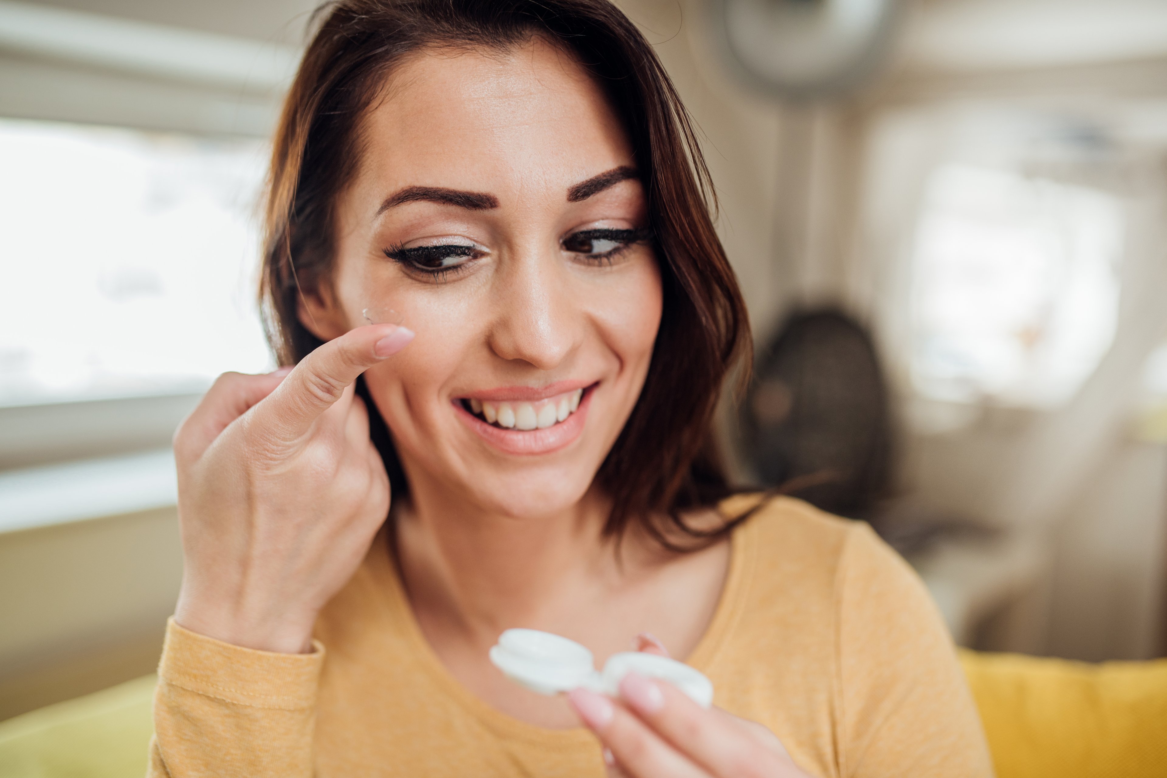 Woman changing contact lenses. 