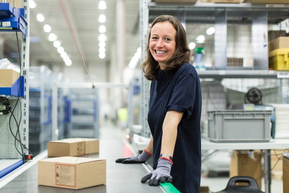 A woman in a warehouse with packages.
