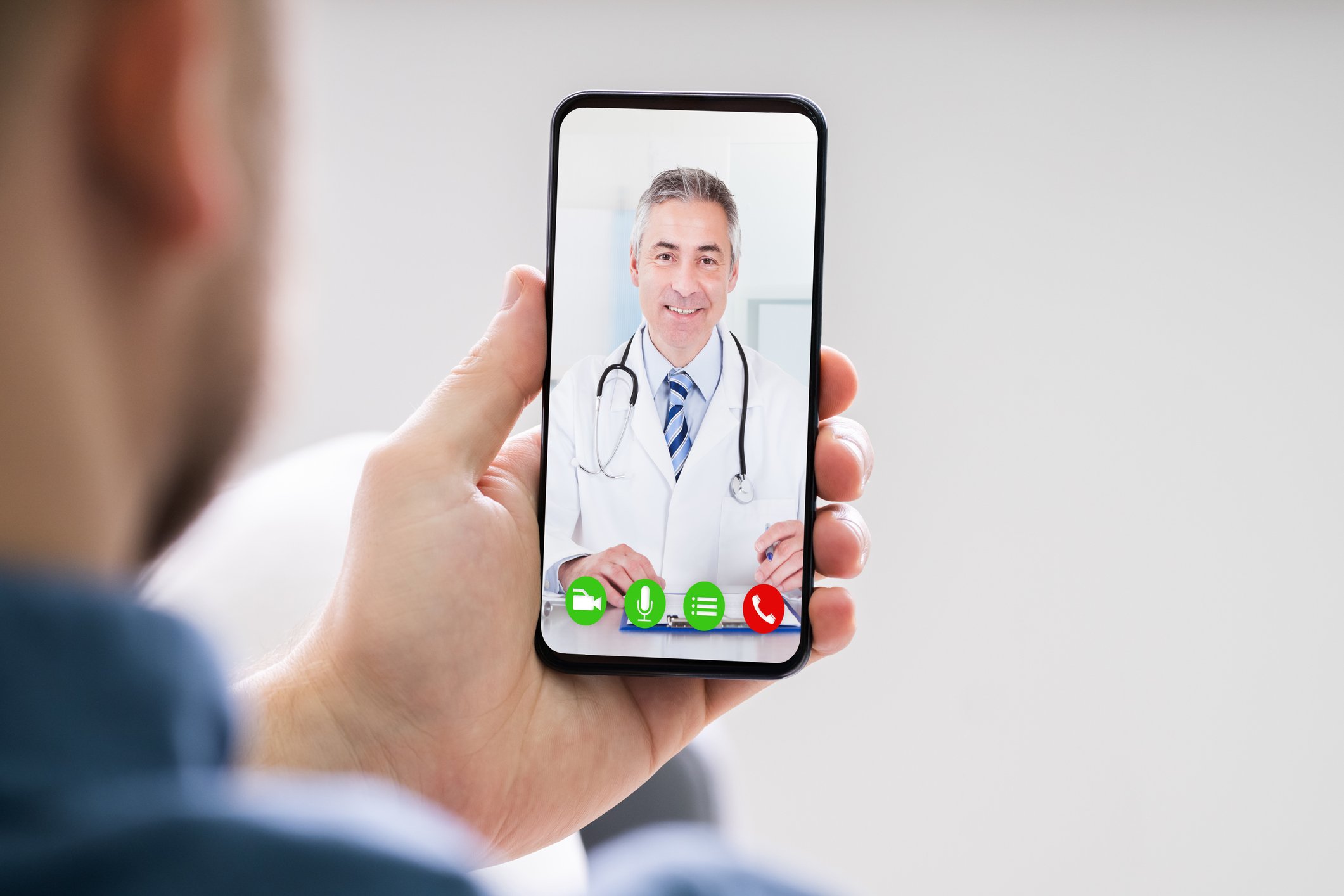 A man having a telehealth visit with a doctor on his mobile phone.