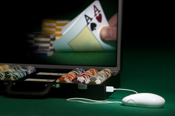 An online poker game showing a player's hand on a screen turning over a pair of aces.