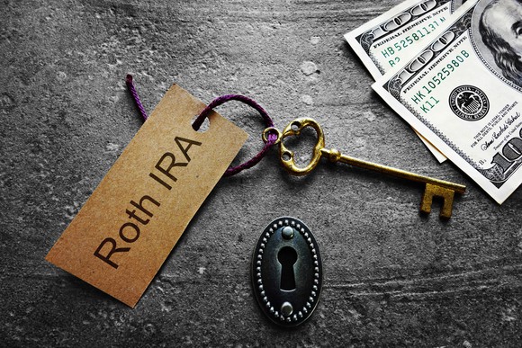 Gold key with Roth IRA tag, with keyhole and cash.