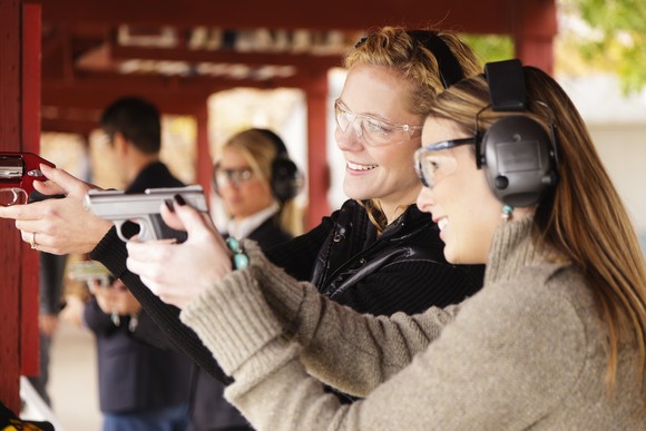 Women shooting handguns at gun range