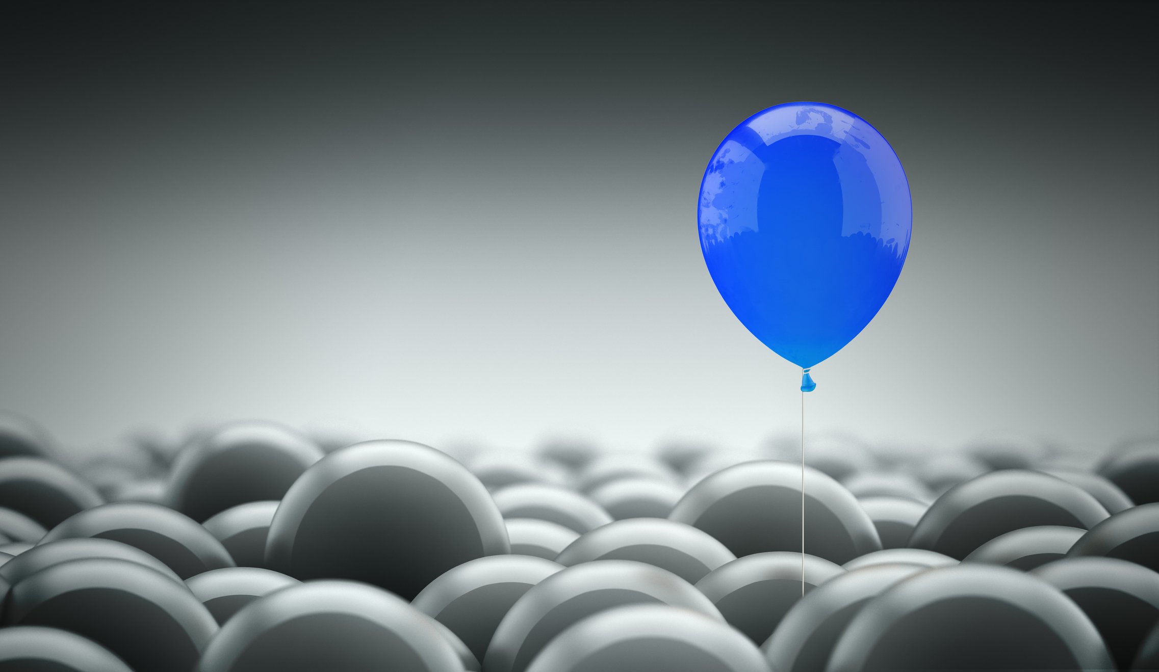 Blue balloon sitting above room full of gray balloons