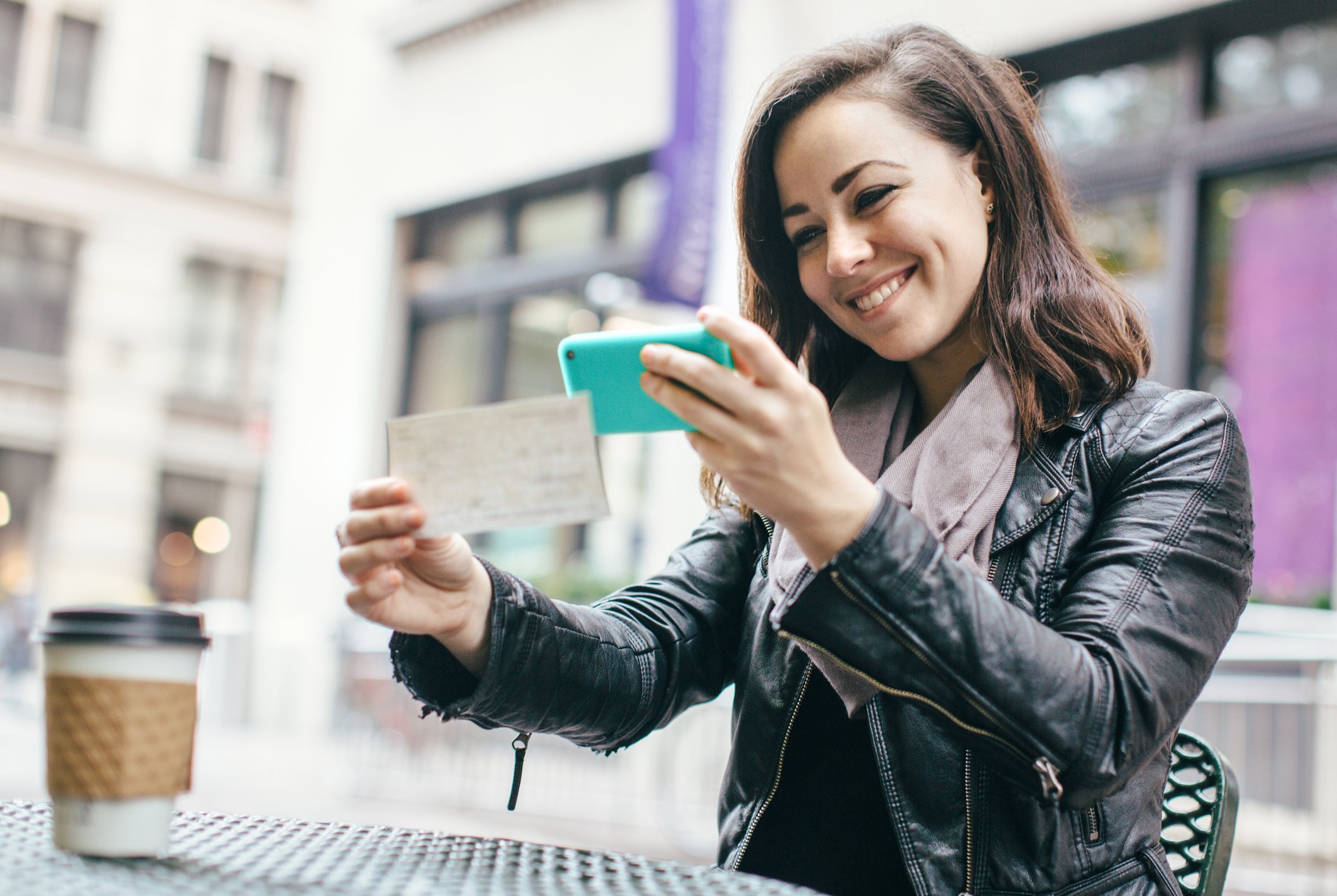 A woman scanning a check with a mobile phone.