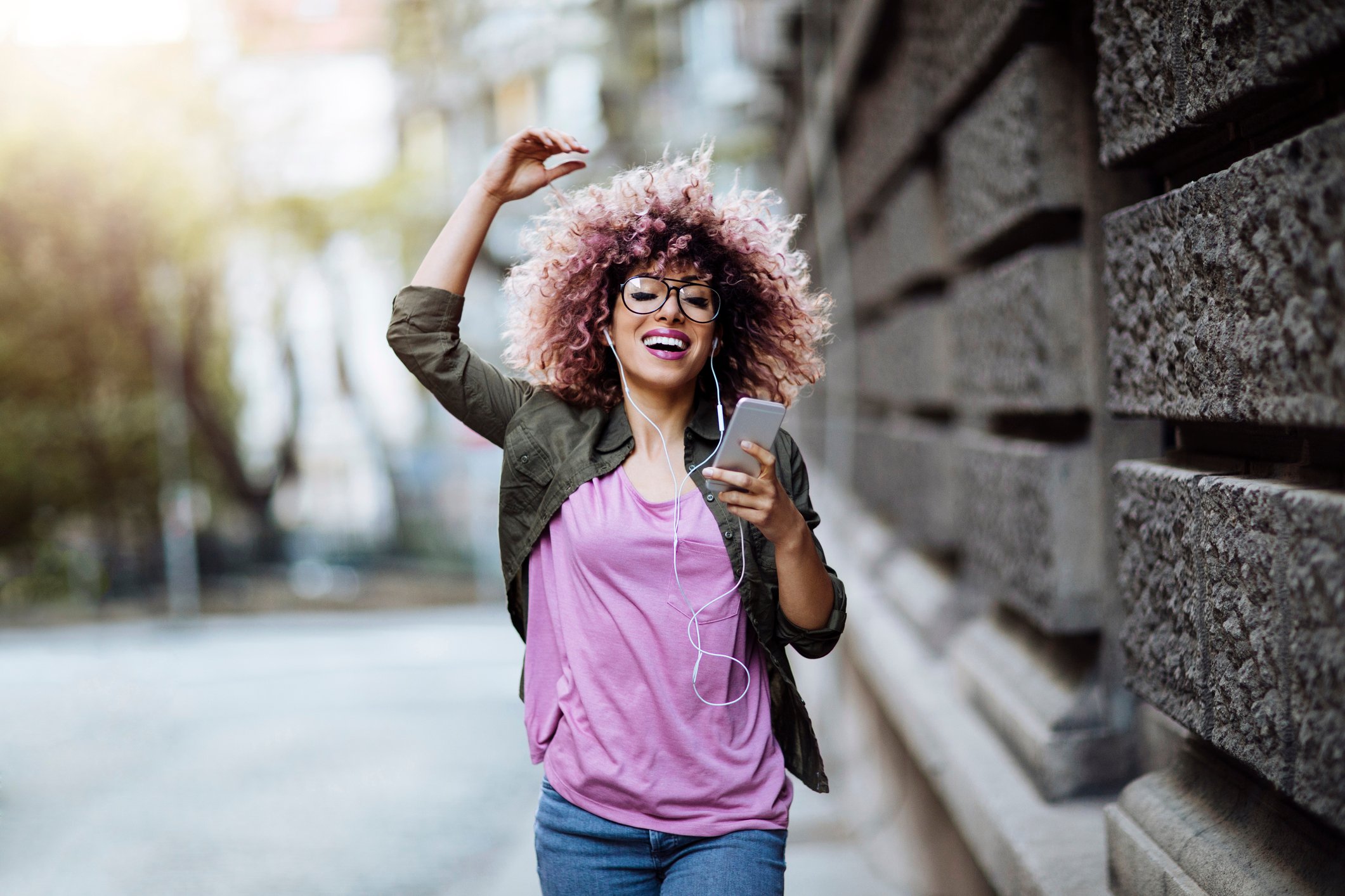 Woman Listening to Music on Sidewalk