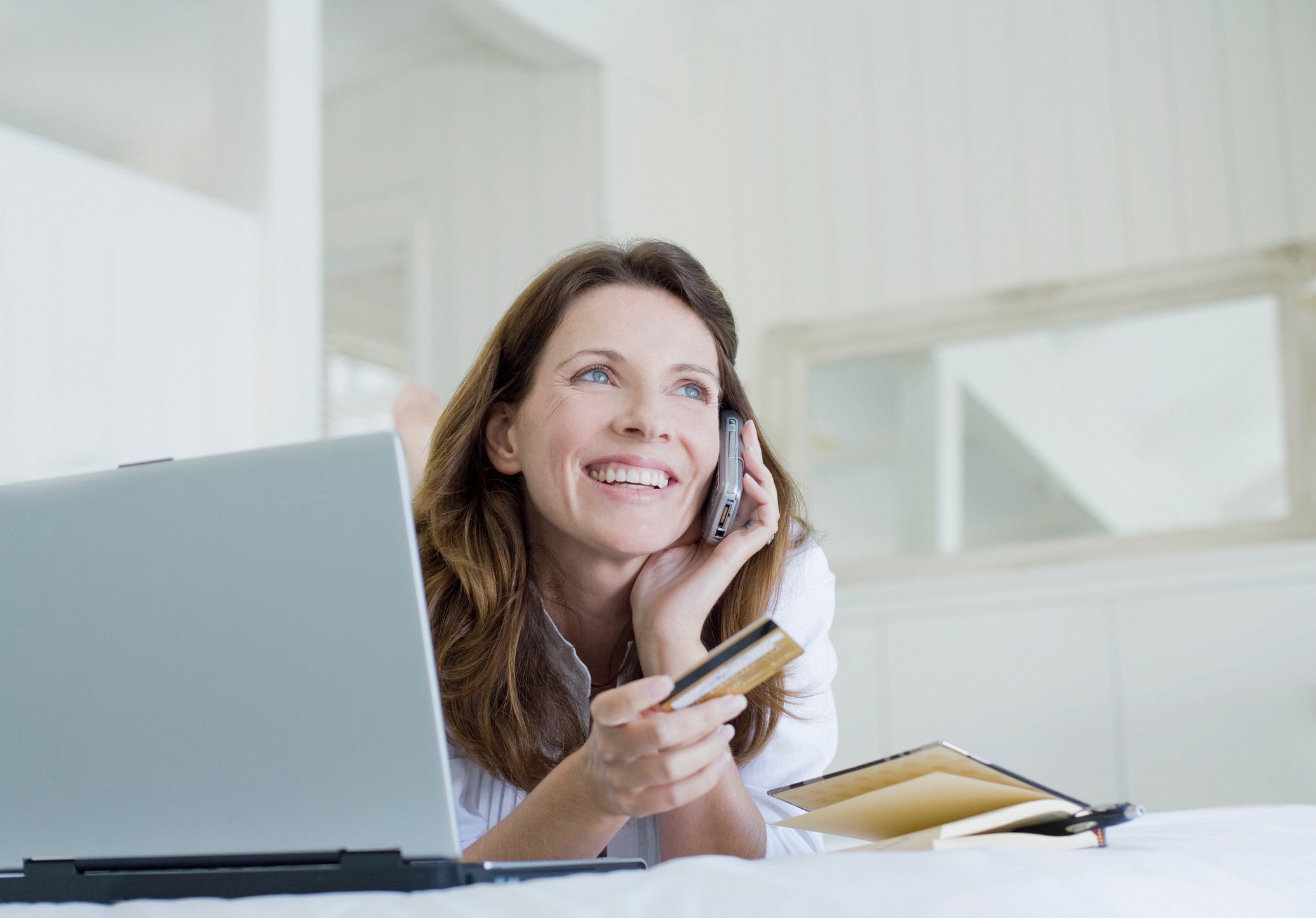 Woman on phone holding credit card.