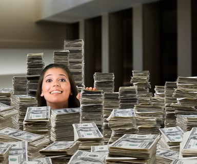 GettyImages-woman surrounded by piles of cash