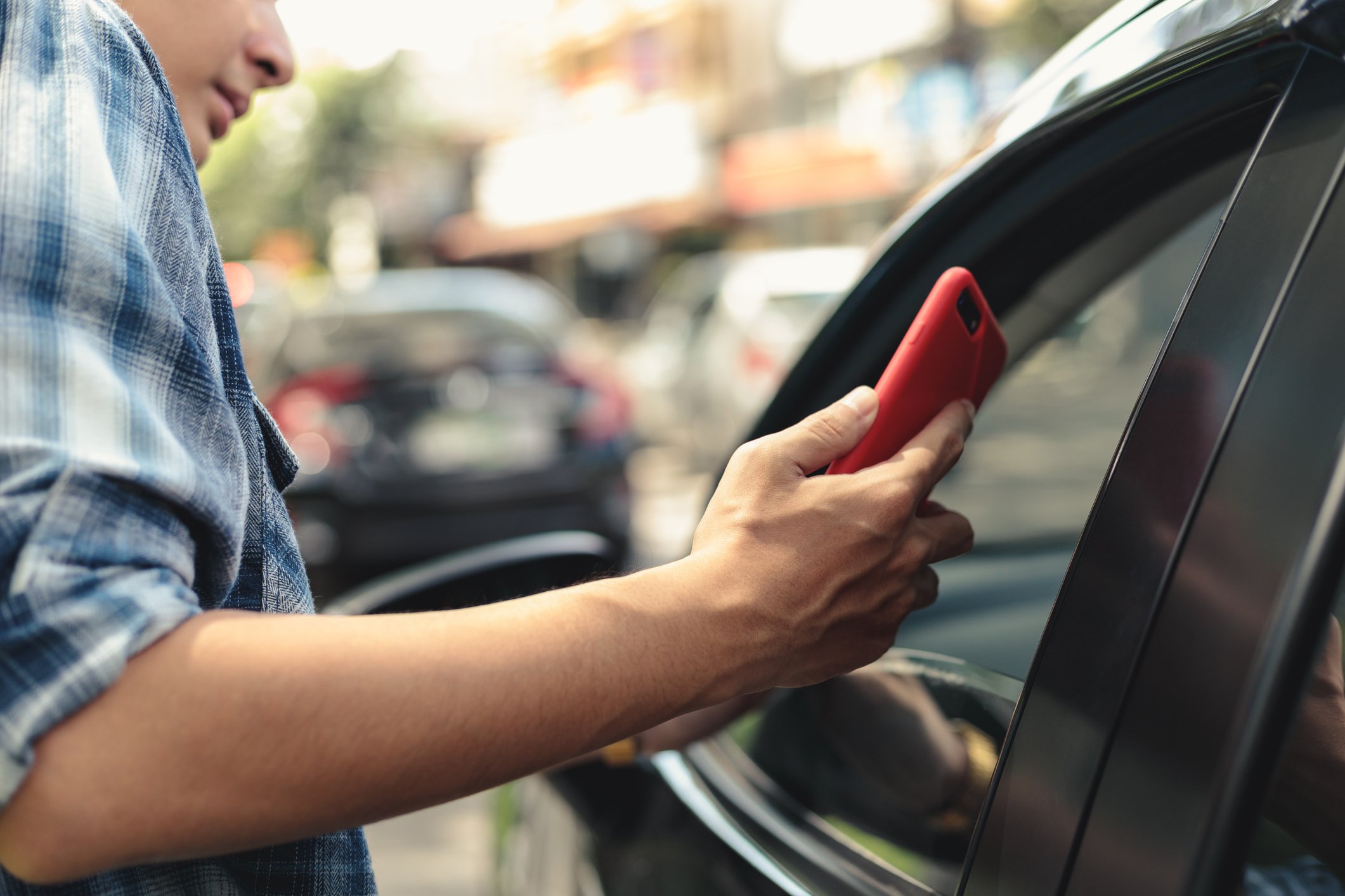 Man with phone approaches arriving vehicle