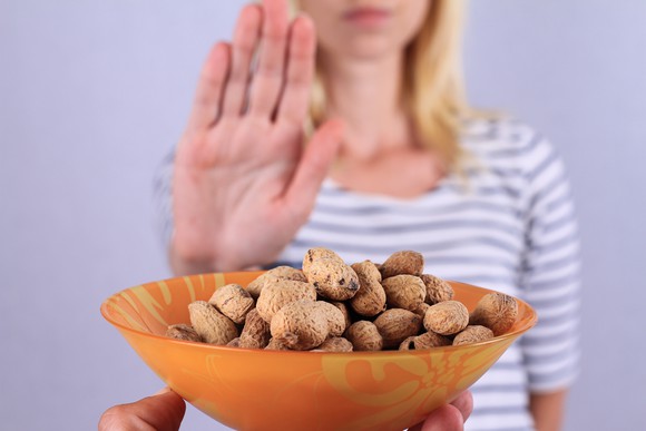 Woman turning down a bowl of peanuts.