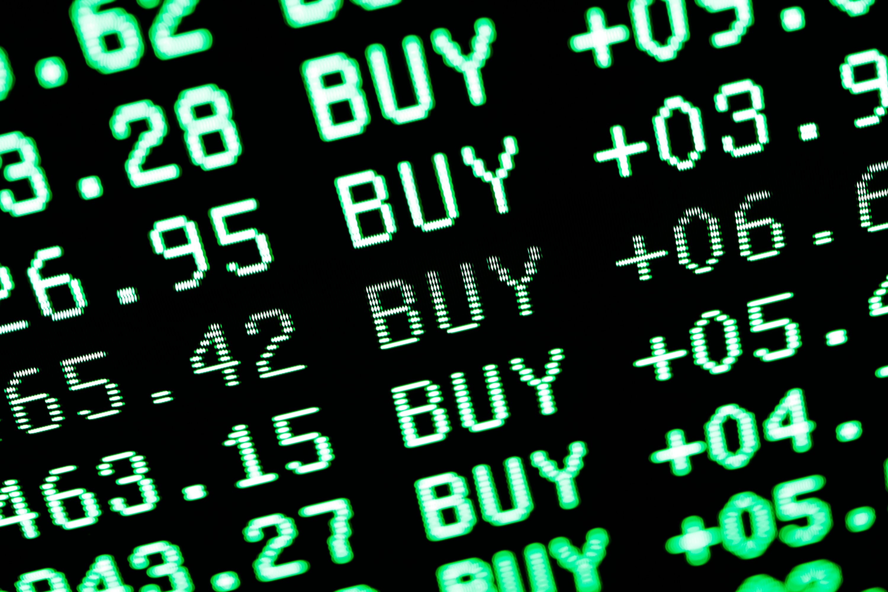 digital screen showing a list of stock buys in green