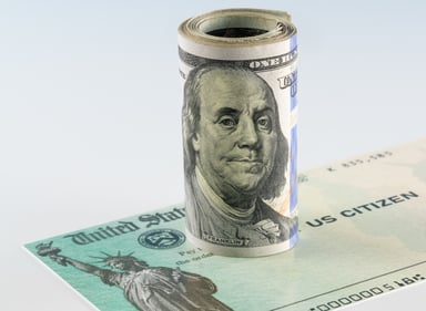 Stimulus check with roll of $100 bills