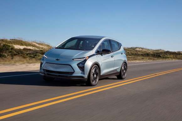 A 2022 Chevrolet Bolt electric vehicle driving on a desert road. 