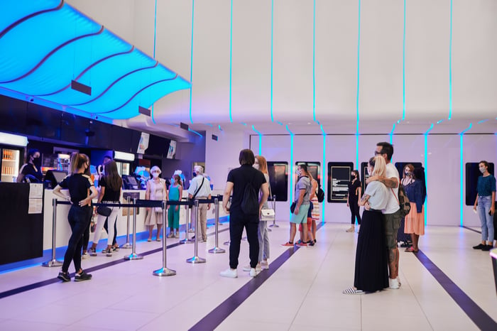 movie theater lobby open with socially distanced crowd