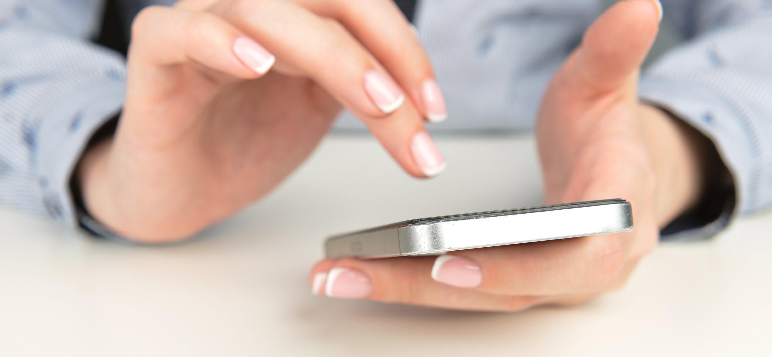 A woman tapping on a mobile phone.