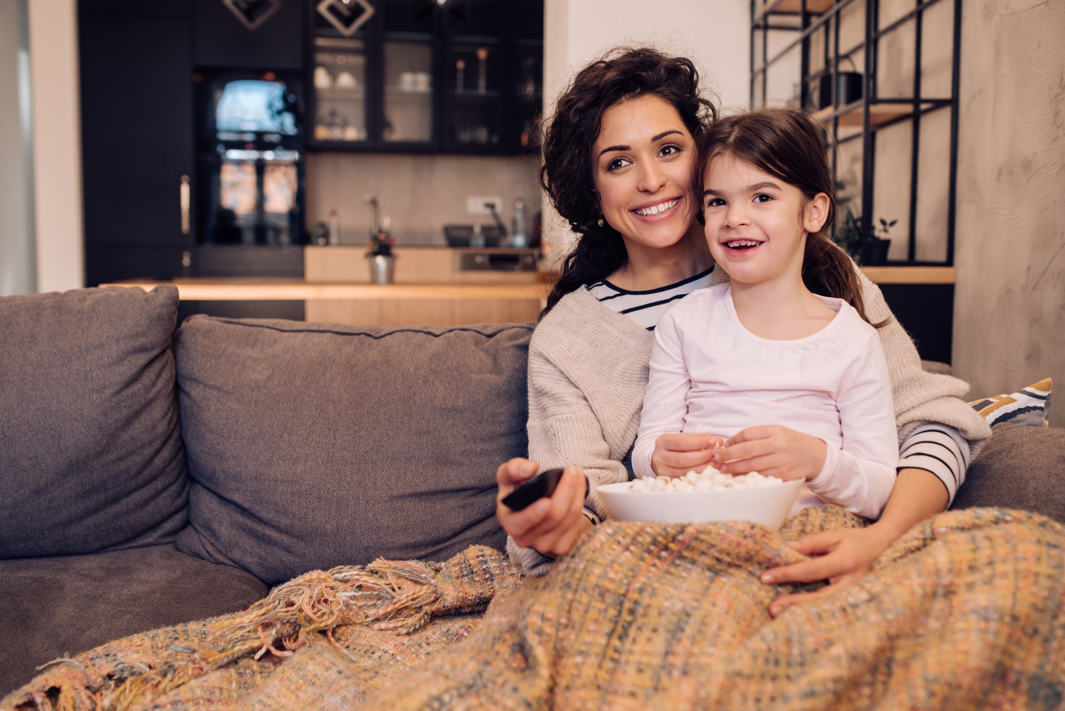 A mother and daughter watching TV together.