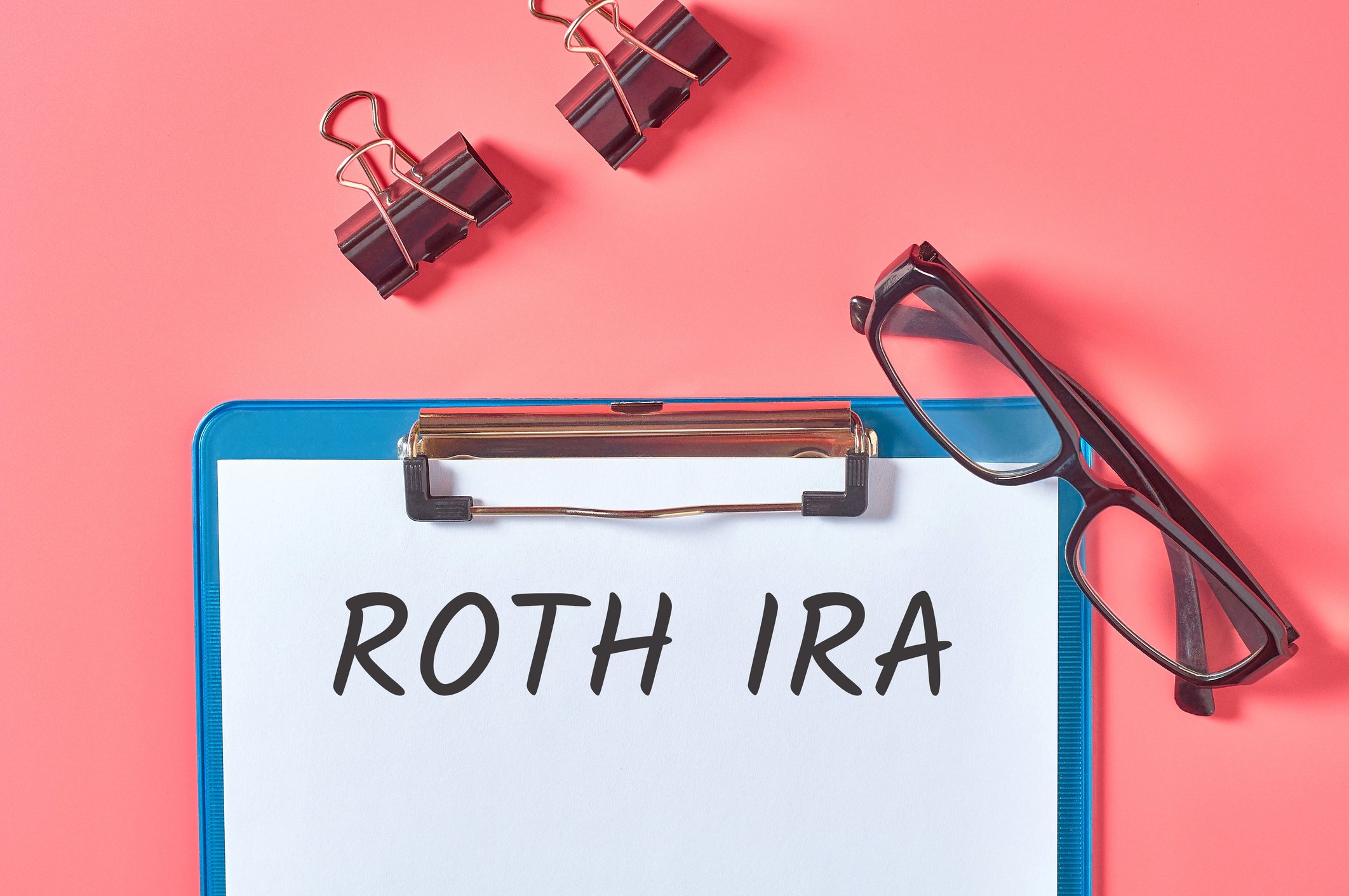 Roth IRA on clipboard with glasses.