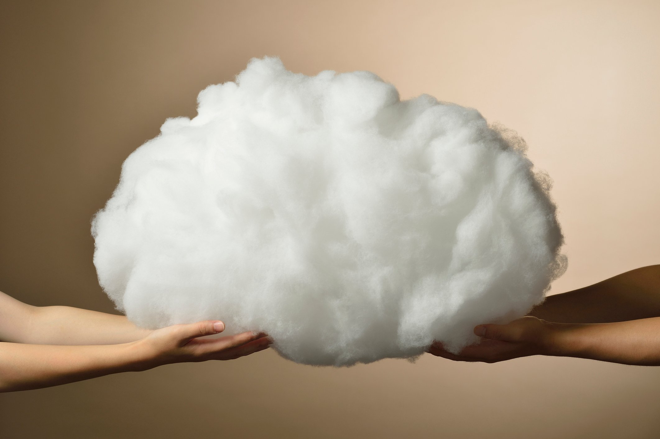 Two sets of hands hold opposite sides of a fluffy cloud. 
