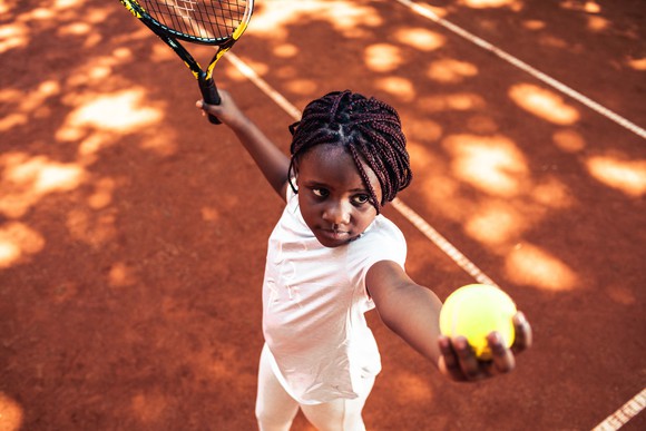 A young girl playing tennis