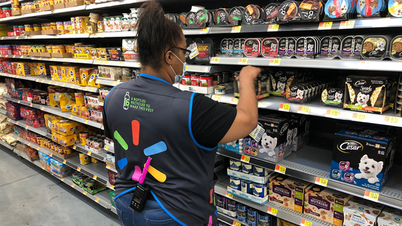 A walmart employee stocks shelves at a store