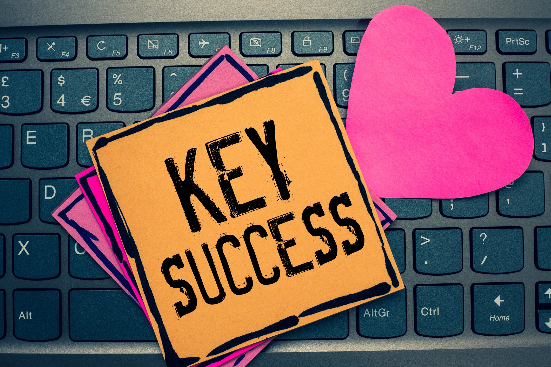 Stickies on a keyboard with Key Success written on the top one.