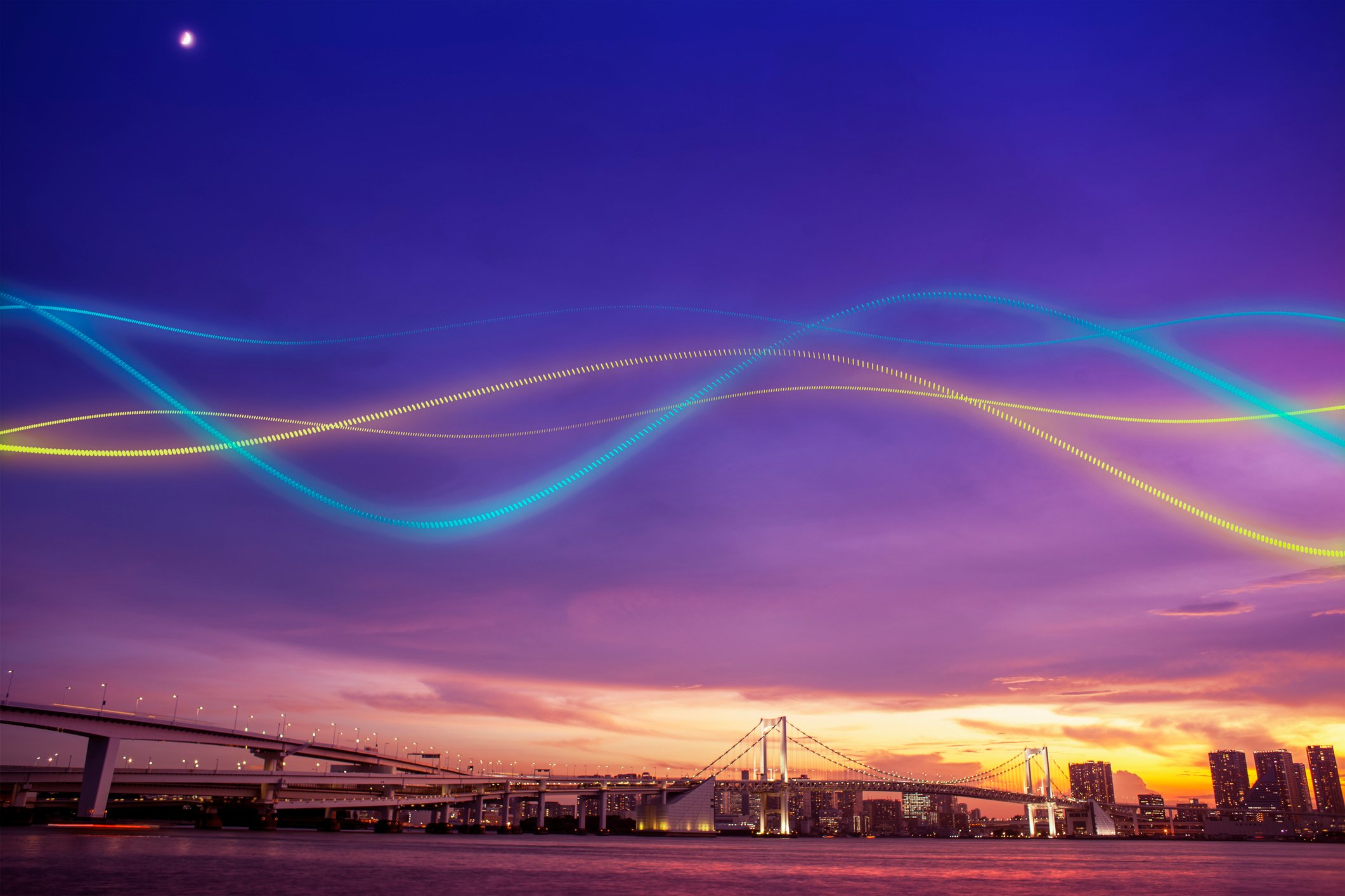 Colored light waves above a city with sun setting in the background