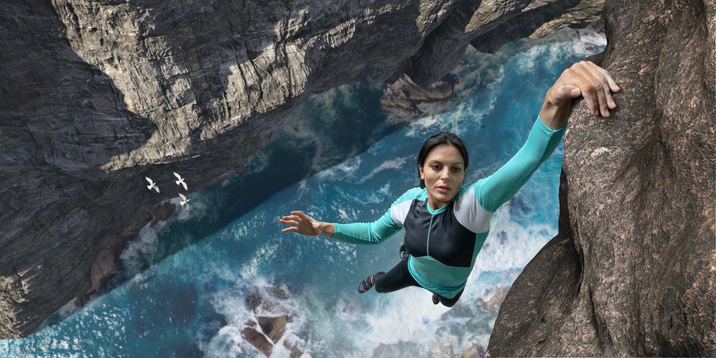 Woman hanging on the edge of a cliff with one hand above a rushing river.