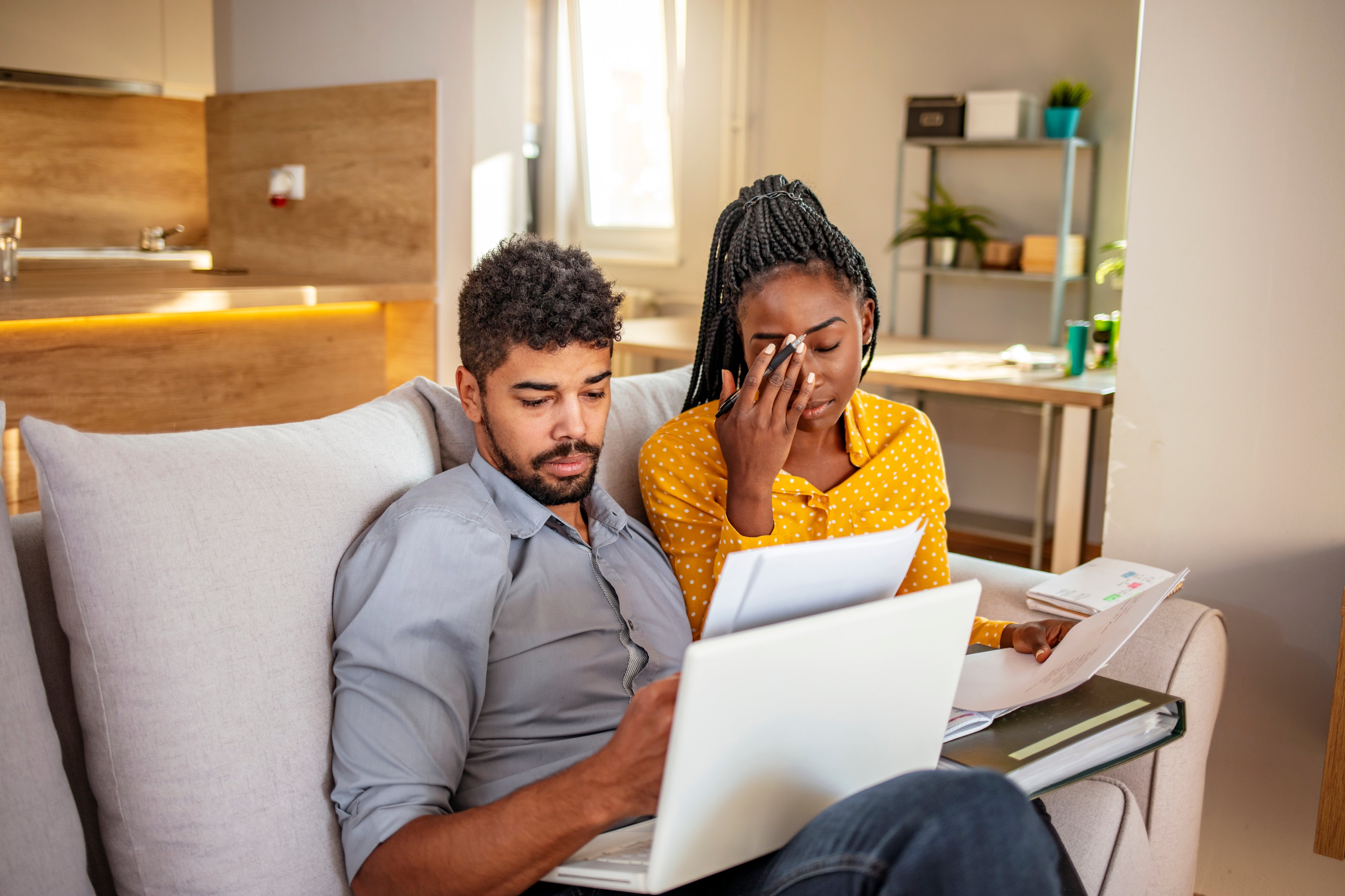 Couple frowning while looking at financial statements. 