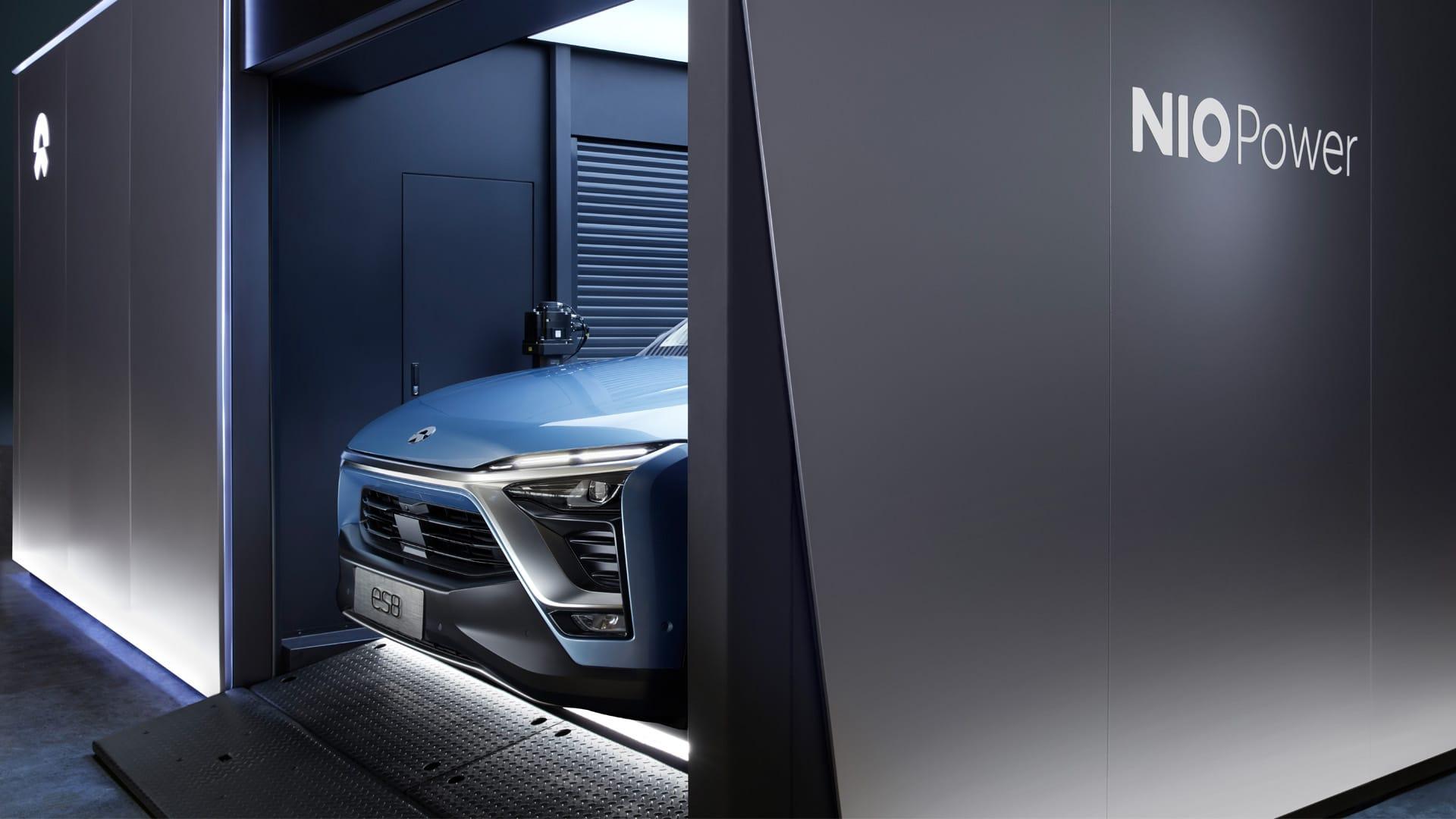 A blue NIO ES8, an upscale electric SUV, emerges from a NIO Power battery-swap station. 