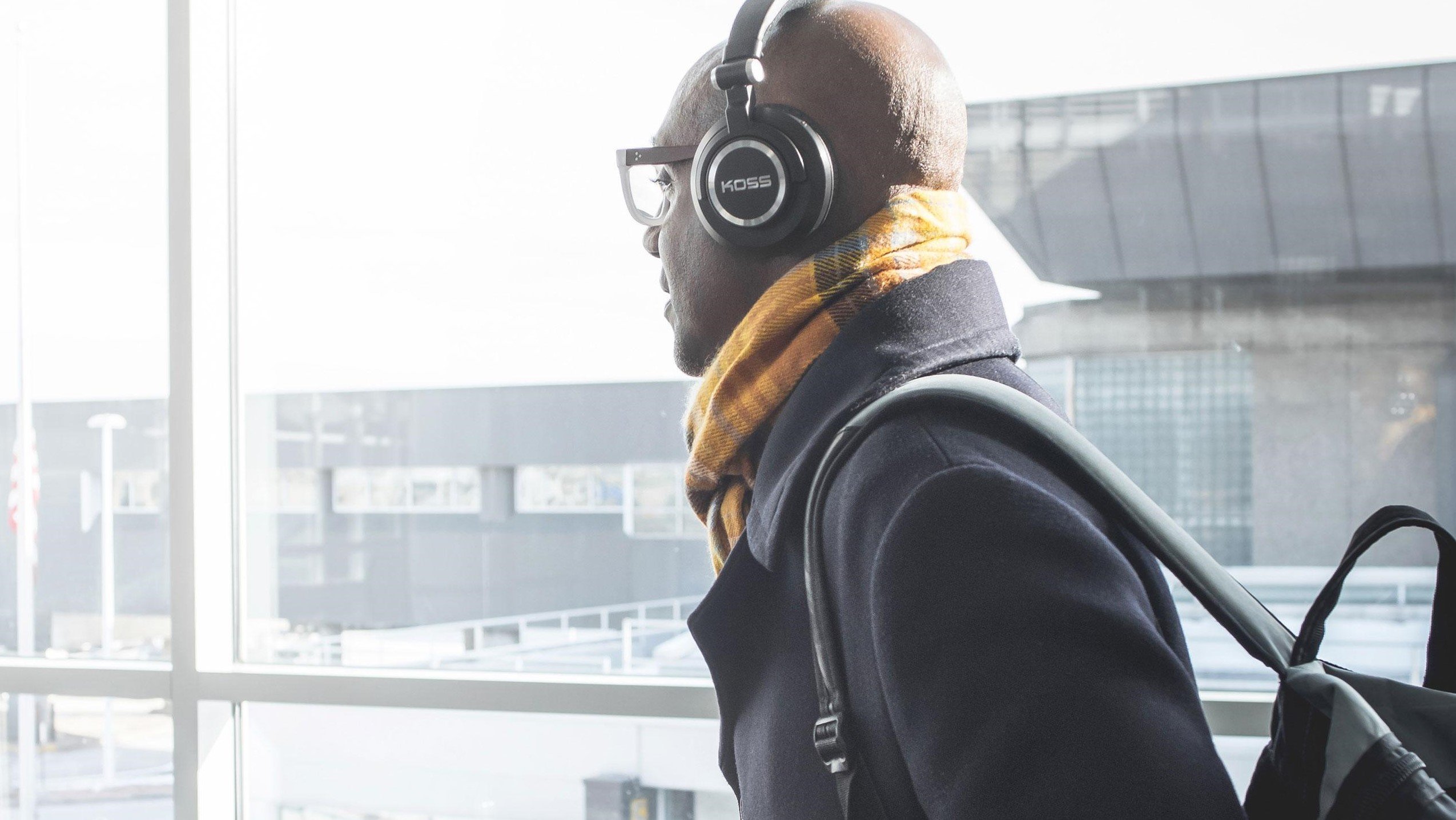 A man wears a pair of Koss headphones.