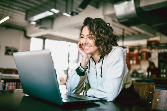 Happy woman looking at the laptop