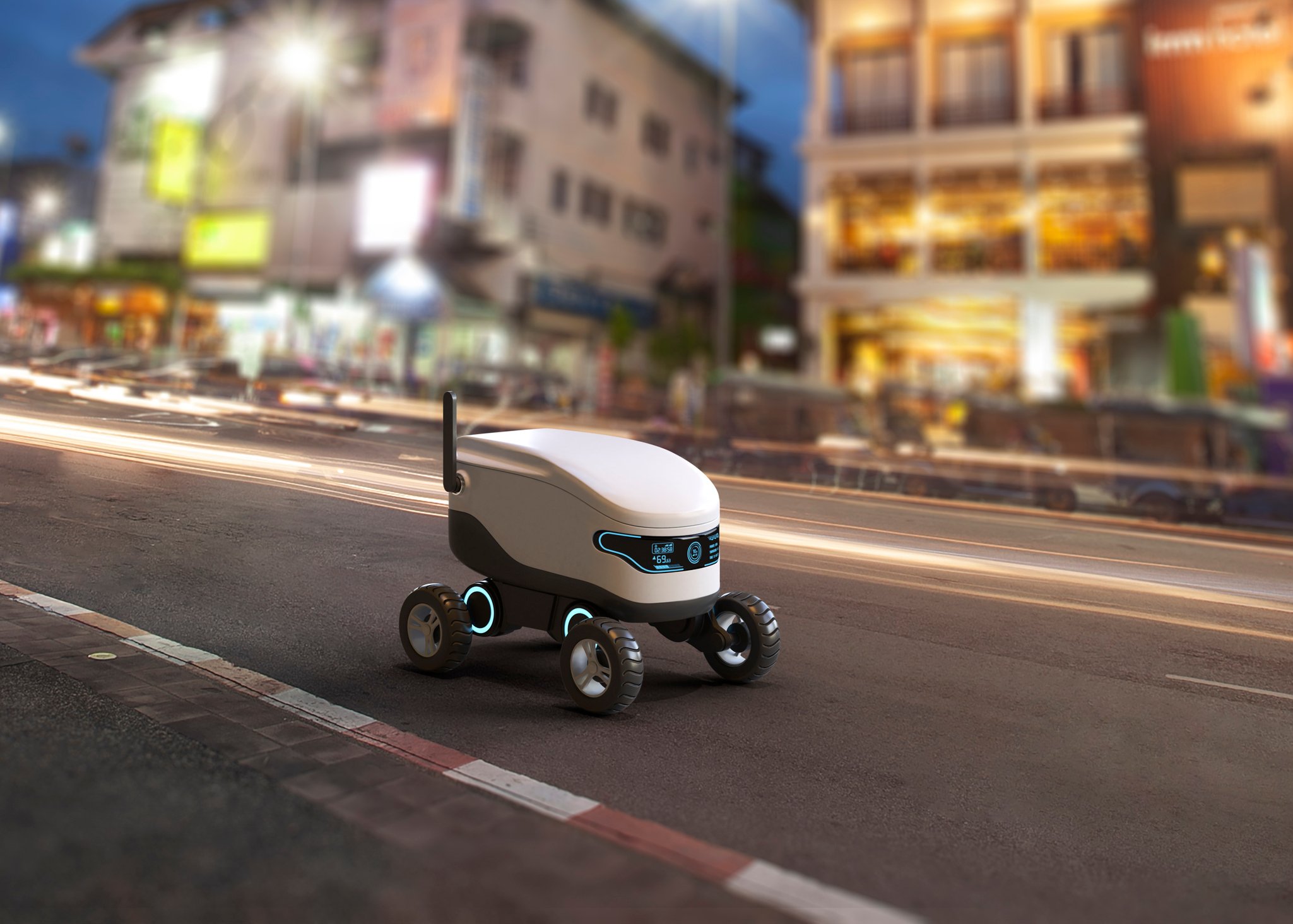 A delivery robot concept shown driving along a street outside lighted nighttime buildings.