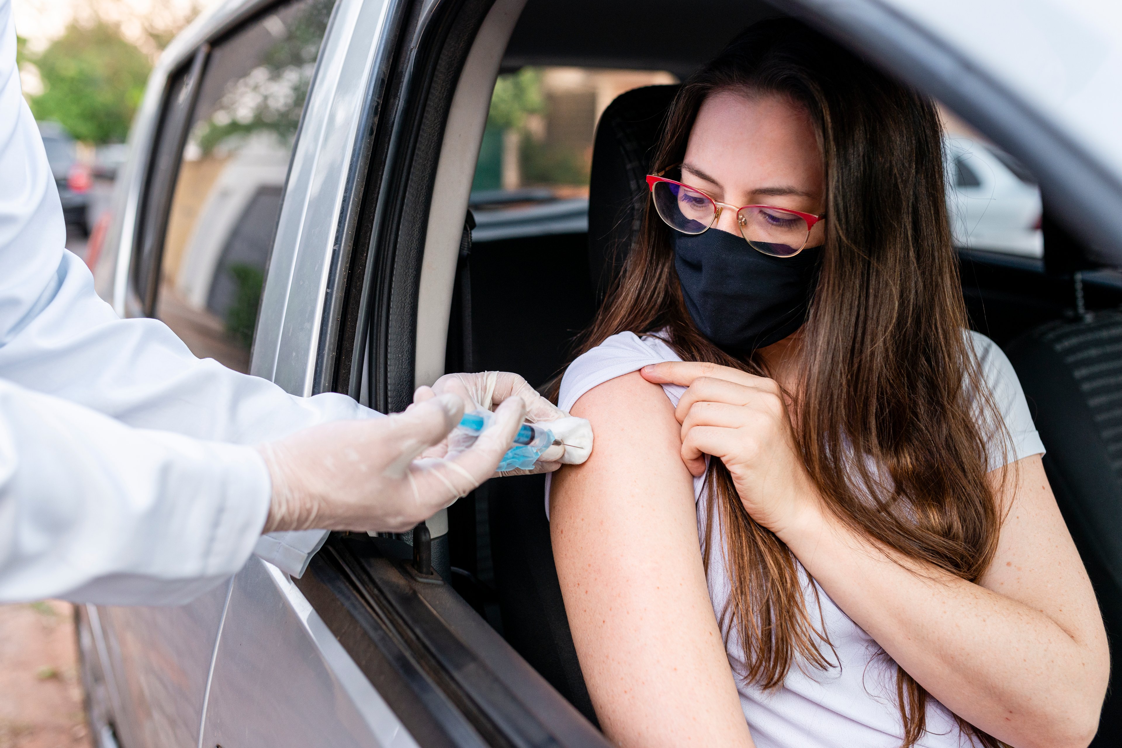 Woman receiving flu vaccine at drive-thru site. 