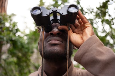 man looking at binoculars
