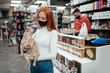 A girl holding a dog in a pet store