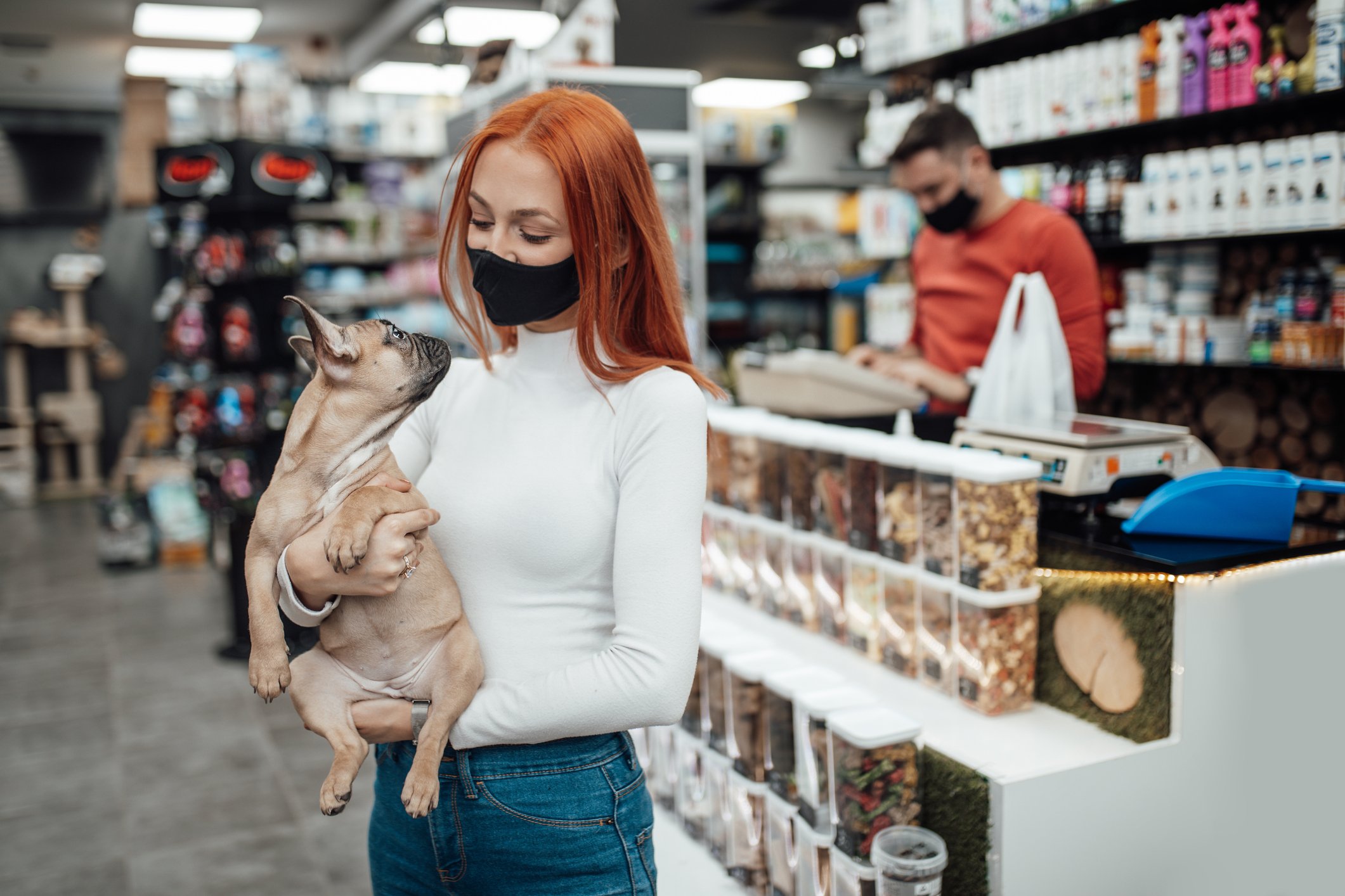 A girl holding a dog in a pet store