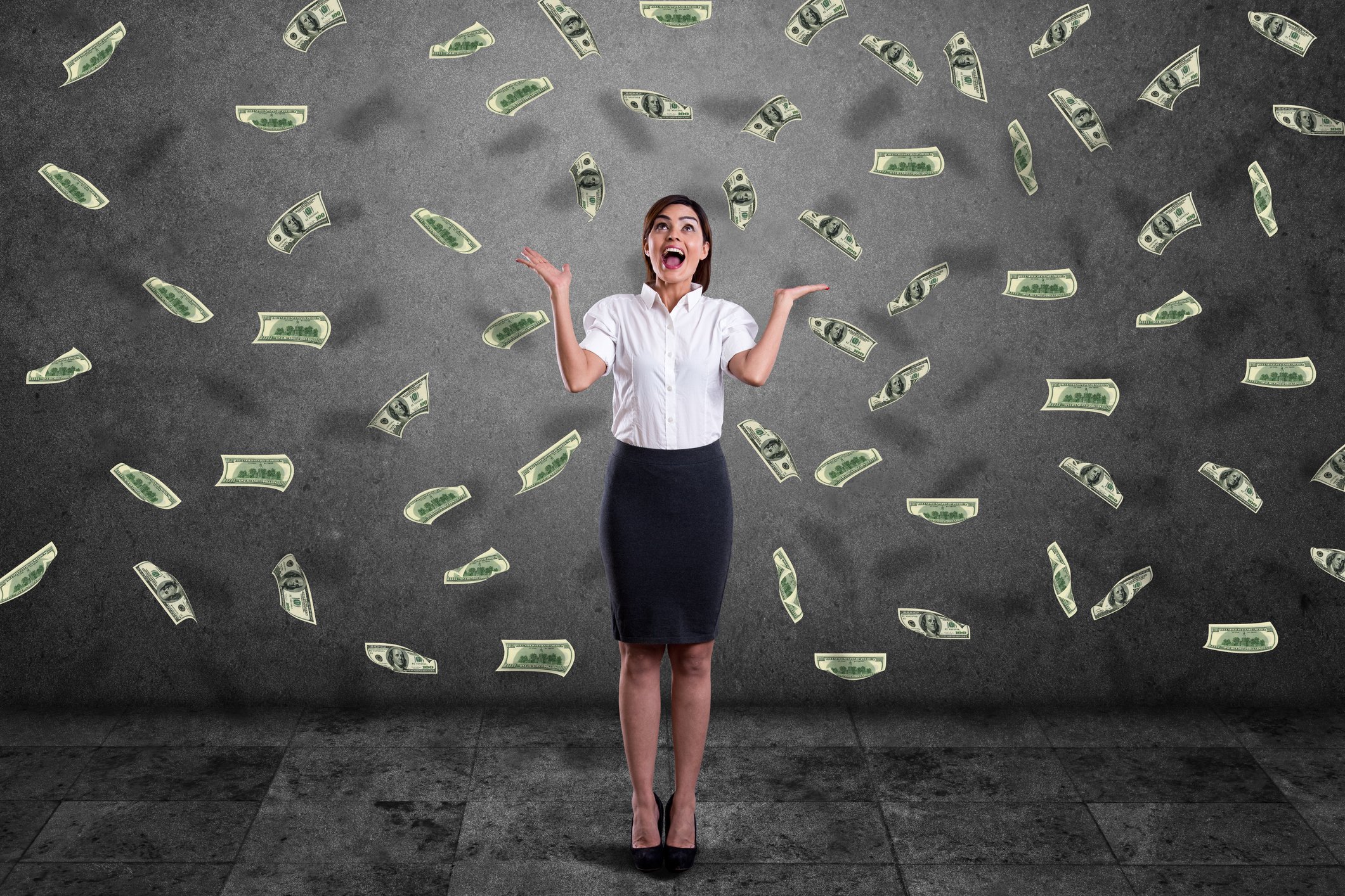 Excited woman with cash falling all around her