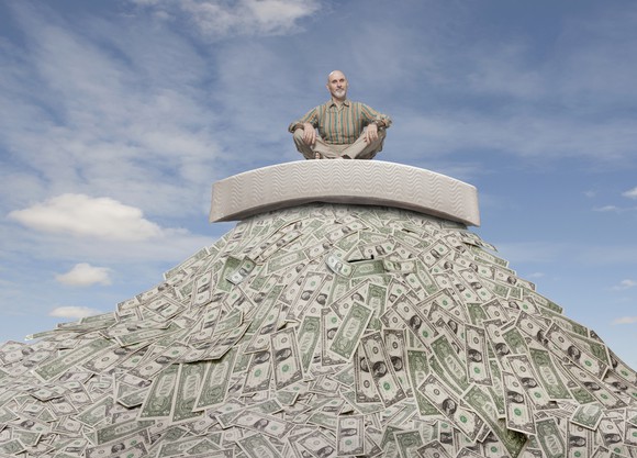 Retiree sitting on top of a large pile of cash