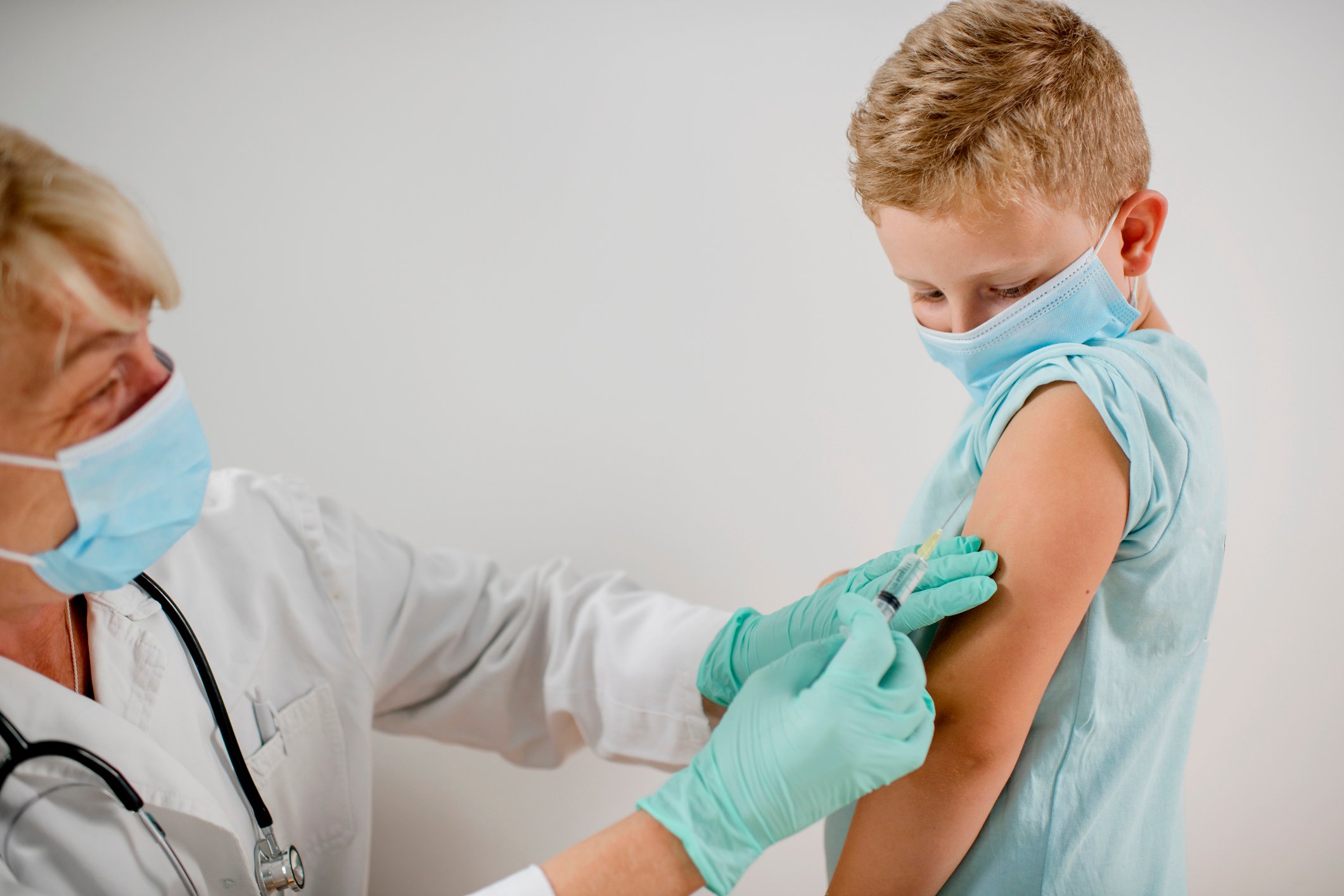 Young boy receiving a shot from a healthcare professional