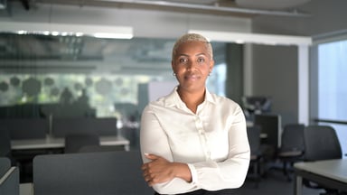a businesswoman stands with crossed arms